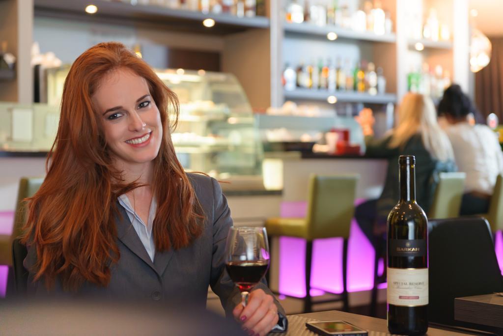 레오나르도 시티 타워 호텔 Giv'atayim 외부 사진 A woman drinking wine